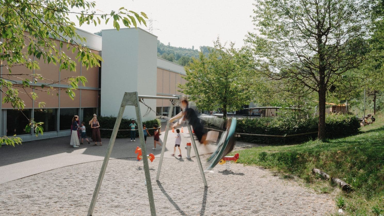 Fröhliche Spielszene auf dem Pausenplatz der HPS - Kinder spielen draussen - Förderung von Bewegung, Selbstbestimmung und sozialem Miteinander.