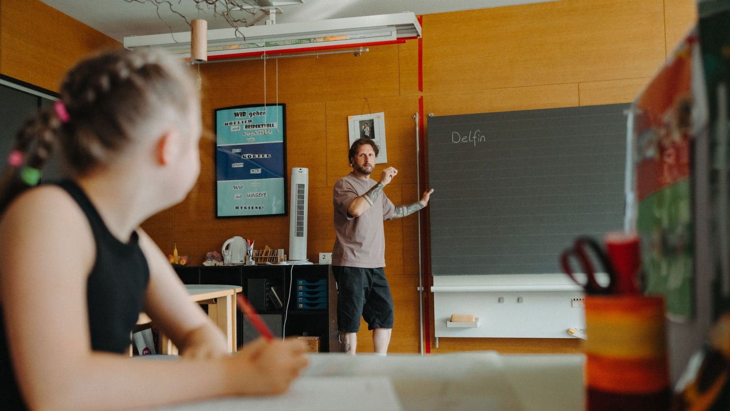 Buntes Klassenzimmer und Tafel mit dem Wort ‘Delfin’ – kreatives Lernen und Sprachförderung an der HPS.
