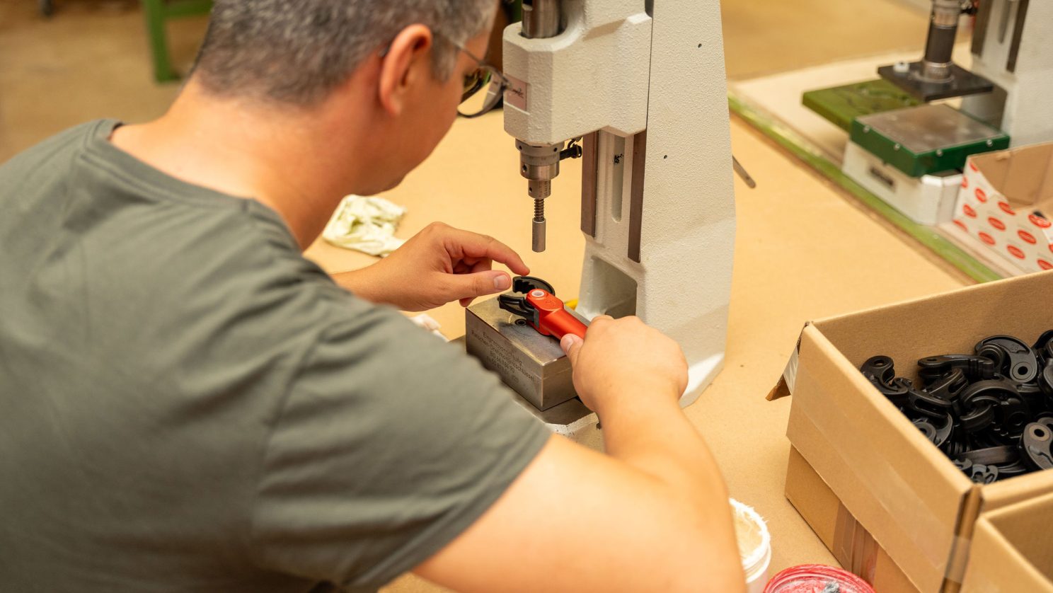 Arbeit in der Produktion: Person montiert Bauteile in der Werkstatt der Stiftung MBF.