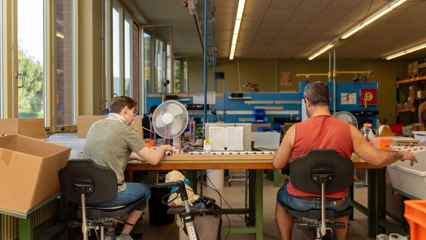 Mitarbeitender mit Unterstützungsbedarf arbeitet präzise in der MBF-Montagewerkstatt.