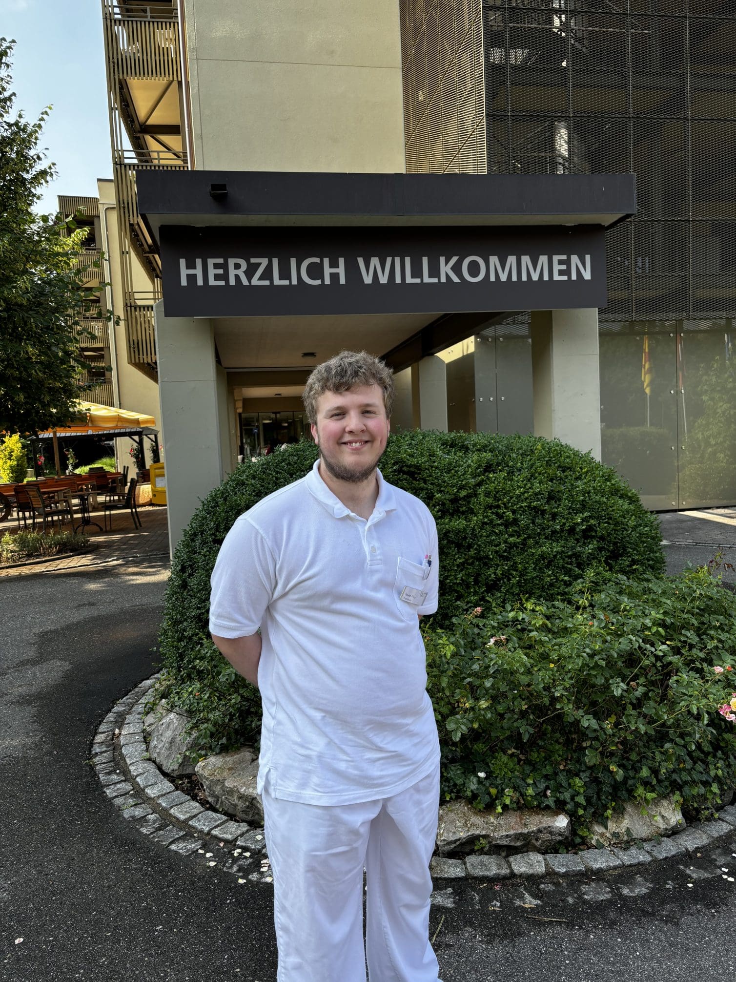 Lernender in weisser Arbeitsleidung steht vor dem Eingang - berufliche Zukunft bei der Stiftung MBF