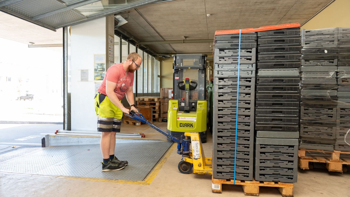 Mitarbeitender bewegt Paletten in der MBF-Logistik – strukturierte Arbeit in der MBF.