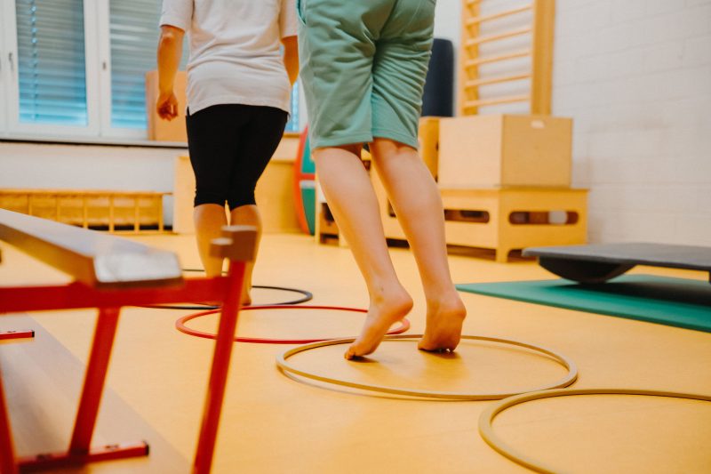Motoriktraining an der HPS Fricktal: Kind geht barfuss durch Reifen und stärkt Bewegung und Selbstvertrauen.