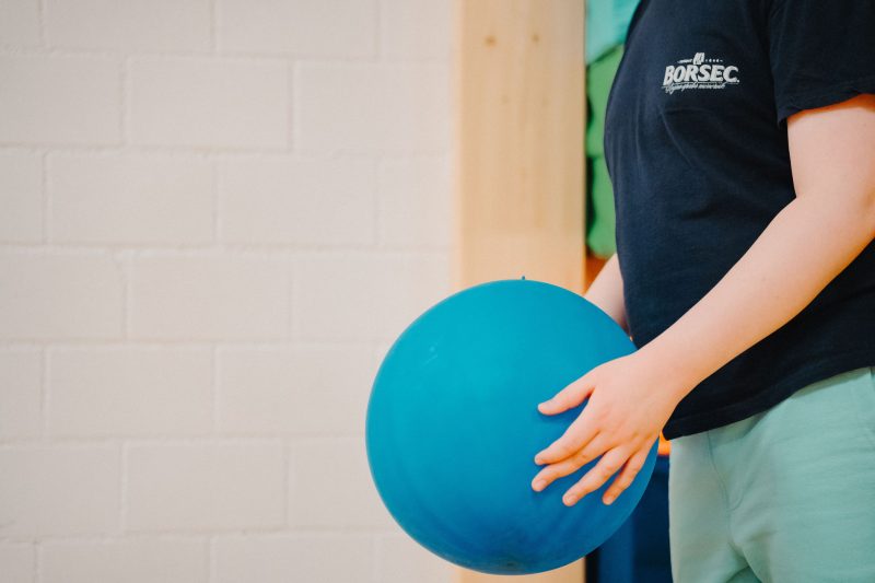 Blauer Ball in der Hand eines Kindes während einer Bewegungseinheit an der HPS Fricktal.